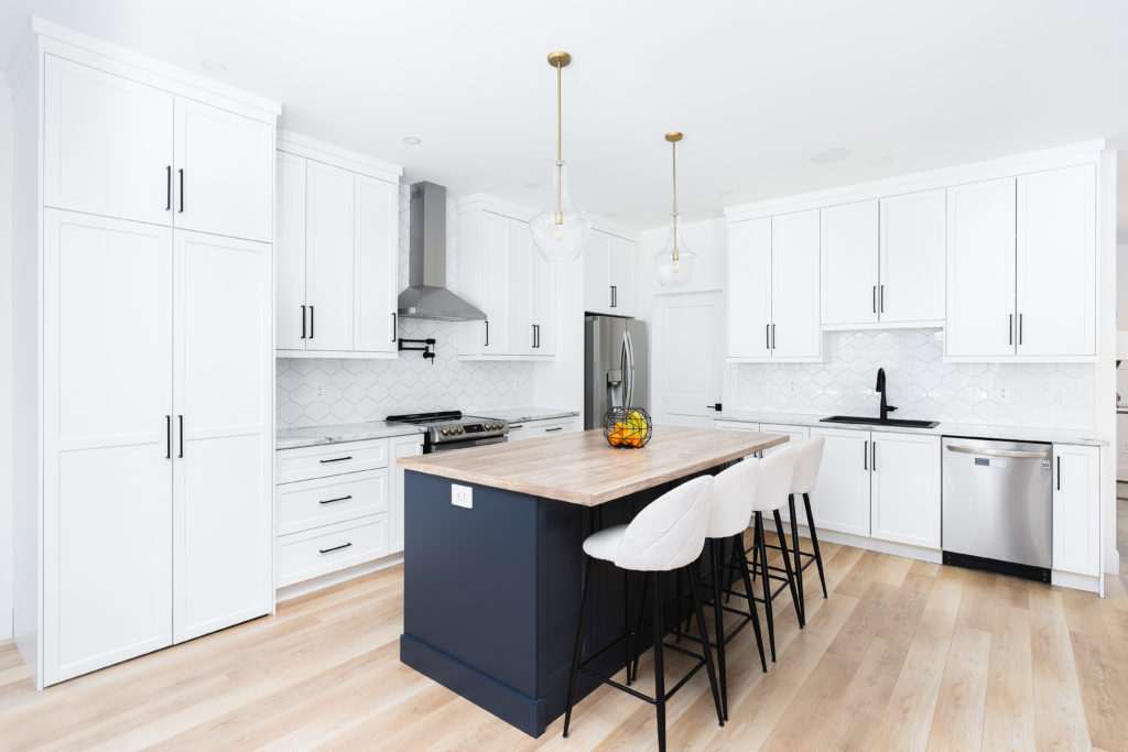 Classic chic kitchen with a blue island and white cabinetry.