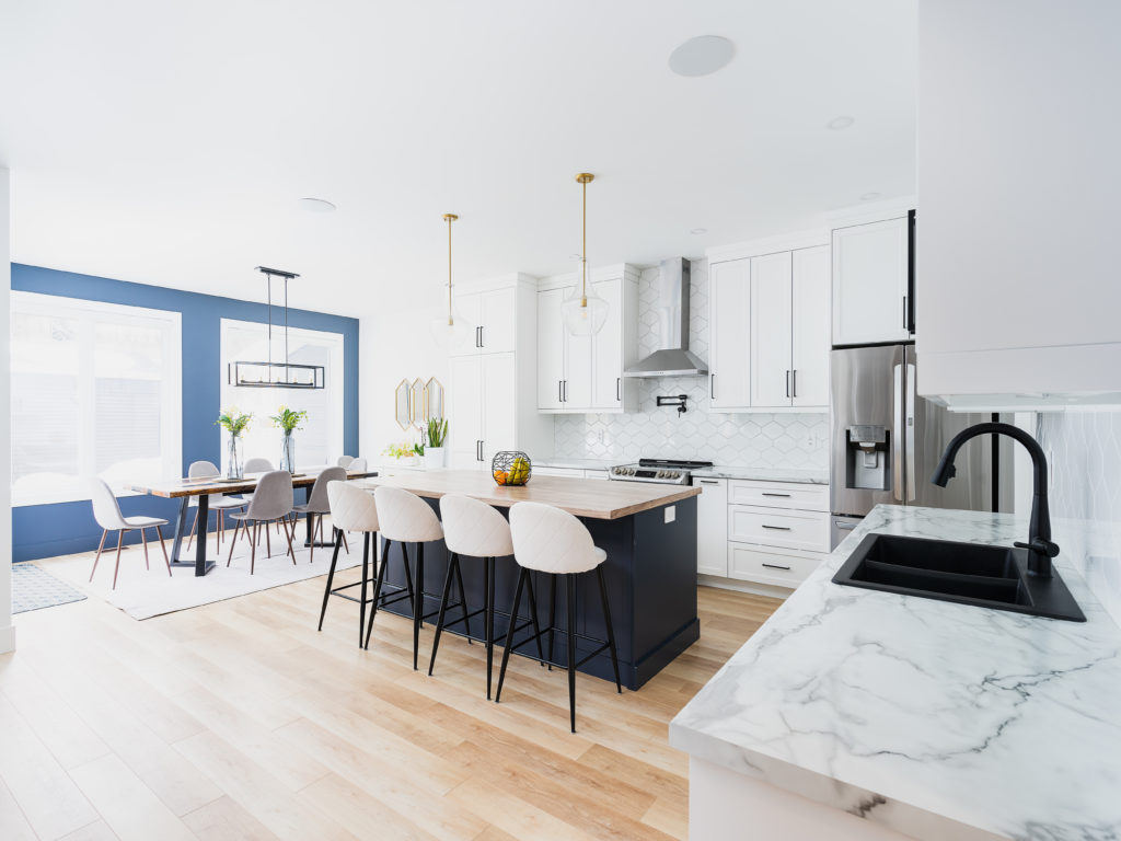 Classic chic kitchen with a blue island and white cabinetry.